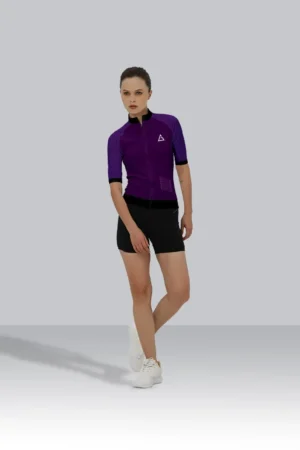 The cyclist wears a purple and black custom race-fit cycling jersey paired with black shorts, showcasing a sleek aerodynamic design.