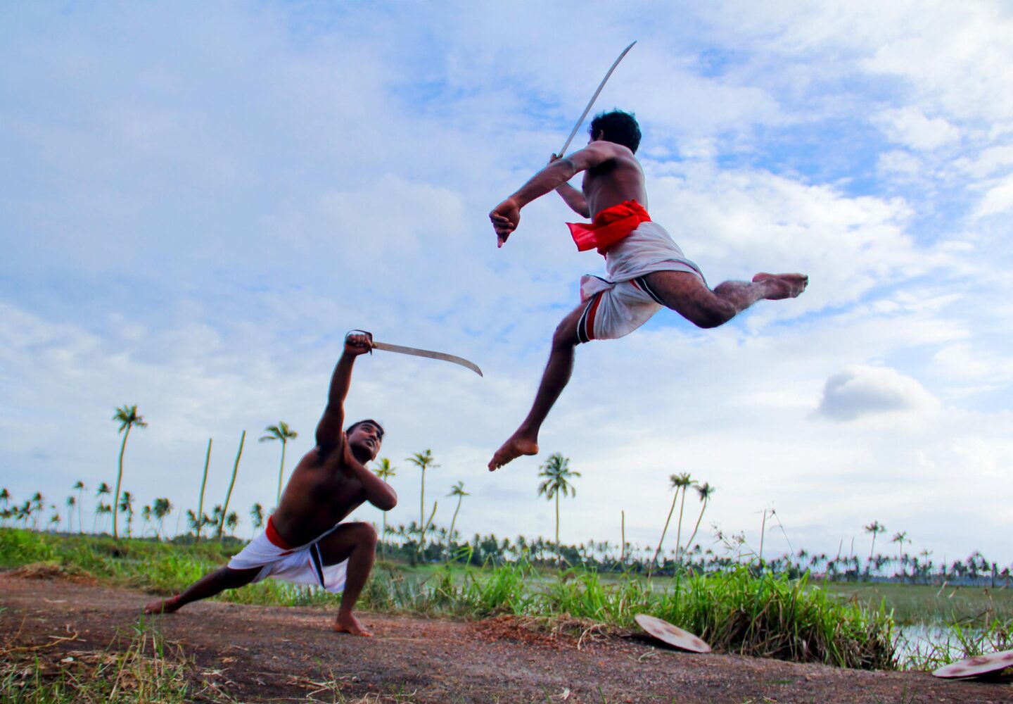 Two Man in White Shorts Fighting Using Sword during Daytime in Kottayam District of Kerala in India