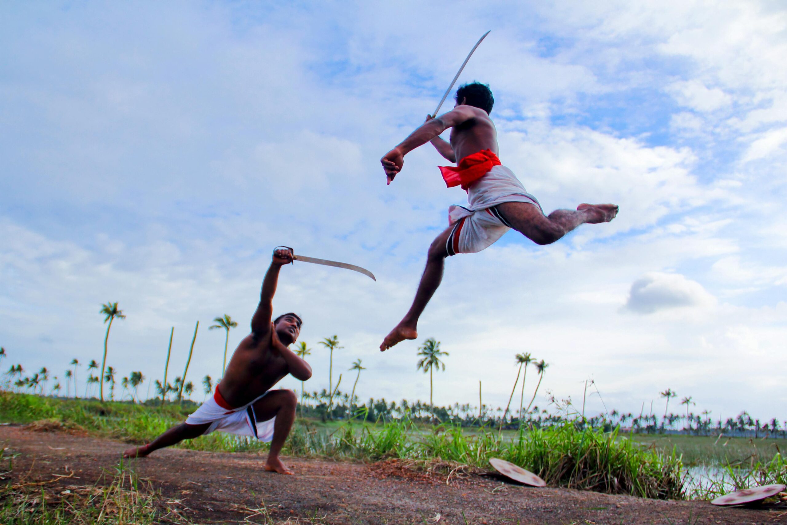 Two Man in White Shorts Fighting Using Sword during Daytime in Kottayam District of Kerala in India